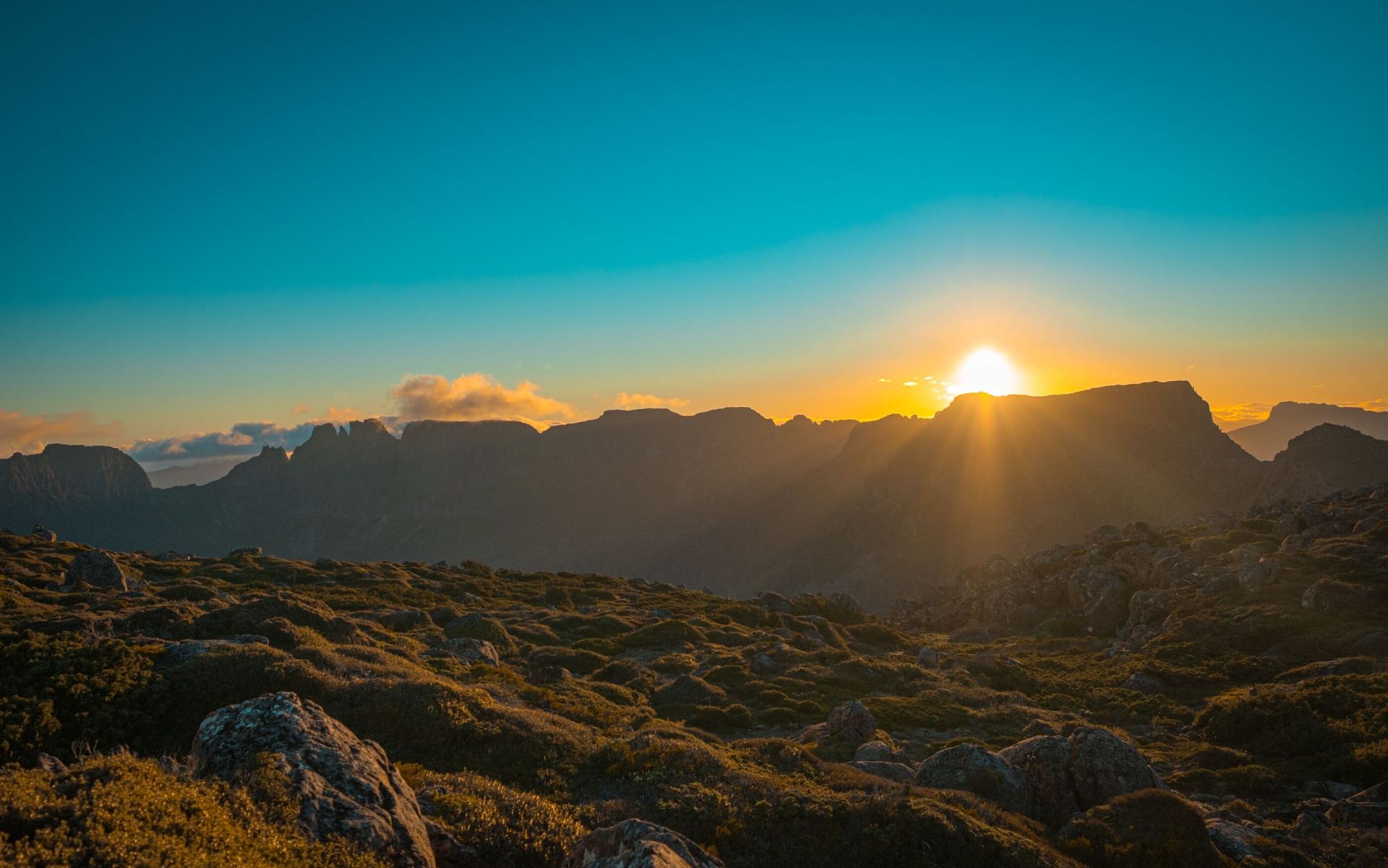 Sunrise breaking over a silhouetted Tasmanian ridgeline
